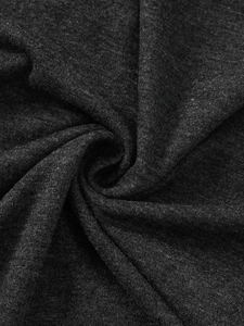 Close-up of soft black knit cotton fabric texture with elegant draped spiral folds