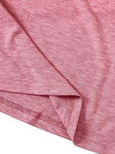 Detailed close-up of pink knit fabric texture and durable double-needle hem stitching