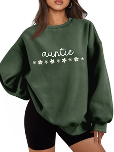 Détail du sweat-shirt oversize auntie vert foncé avec imprimés marguerites sur mannequin