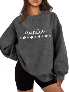 Détail du sweat gris auntie avec motifs marguerites et poignets côtelés sur modèle
