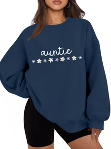 Détail du sweat bleu marine oversize avec texte auntie blanc et imprimés marguerites