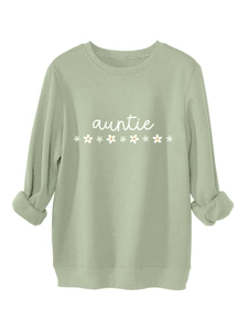 Détail du texte auntie blanc et de l'imprimé marguerite sur le sweat épais vert sauge