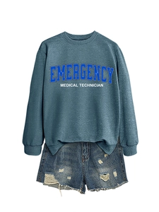 Detail of blue emergency medical technician sweatshirt and ripped denim shorts