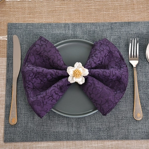 Portatovaglioli a fiore in acrilico bianco con perla su tovagliolo jacquard viola