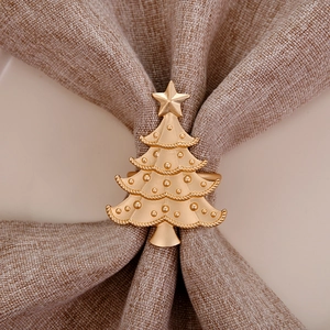 Golden Christmas tree napkin ring with star top on beige linen napkin for table decor