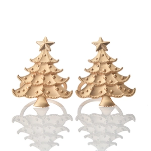 Detailed close-up of matte gold Christmas tree napkin rings with embossed textures