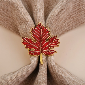 Détail macro du rond de serviette feuille d'érable rouge avec finition dorée sur lin