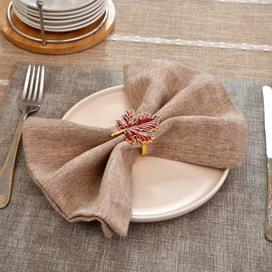 Gros plan d'un rond de serviette en forme de feuille d'érable rouge sur une table dressée