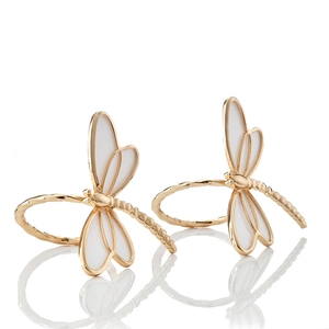 Detail of golden dragonfly napkin rings with white enamel wings on white background