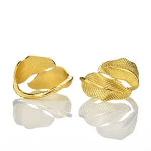 Golden leaf napkin rings with realistic vein textures shown on a white reflective base