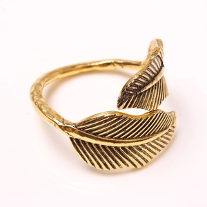 Detailed close-up of golden leaf napkin ring featuring intricate leaf veins and branch texture
