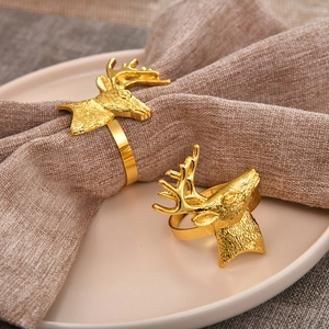 Set of two gold metal reindeer head napkin rings for festive Christmas table decor