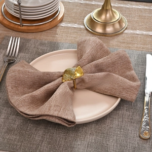 Rond de serviette en forme de coquillage doré sur serviette en lin pour table élégante