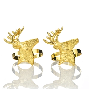 Detail of golden reindeer head napkin rings with fine engraved texture and polished finish