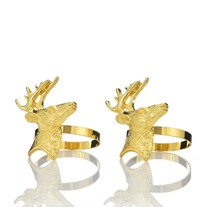 Detailed close-up of golden reindeer head napkin rings with textured metal relief and finish