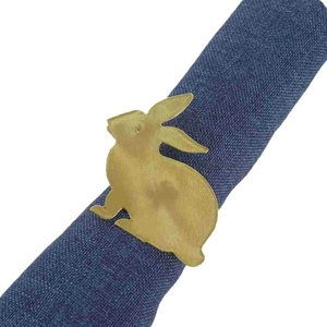 Vintage gold rabbit napkin ring in animal shape on blue linen cloth for Easter dining