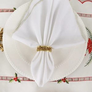 Macro shot of luxury gold napkin ring with crystals on white fabric and holiday tablecloth