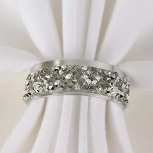 Macro shot of luxury silver napkin ring with shimmering rhinestones on white cloth
