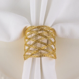 Gold mesh napkin ring with woven hollow design on a white cloth for table setting