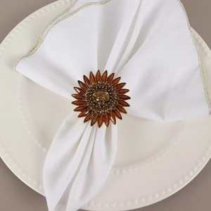 Elegant amber sunflower napkin ring with crystal center on a white fabric napkin