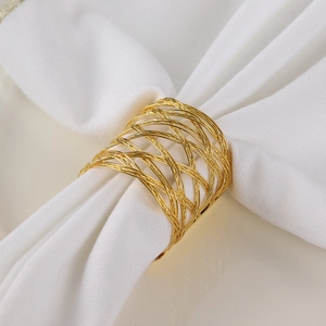 Golden woven mesh metal napkin ring with hollow design on a white cloth napkin