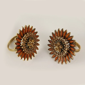 Set of two vintage sunflower napkin rings with rhinestones on a clean grey background
