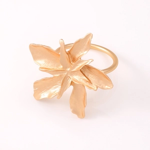 Detailed view of 3D golden alloy flower napkin ring with matte finish and textured petals