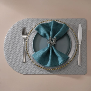 Detail of silver coral branch napkin ring on a blue napkin with elegant table setting