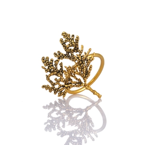 Retro golden coral branch alloy napkin ring with creative botanical design on white background