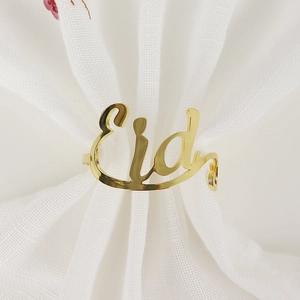 Golden Eid alphabet metal napkin ring with polished mirror finish on white fabric