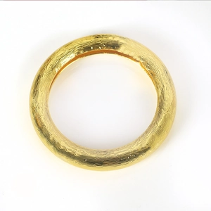 Close-up of golden napkin ring featuring a sophisticated hammered bark texture finish