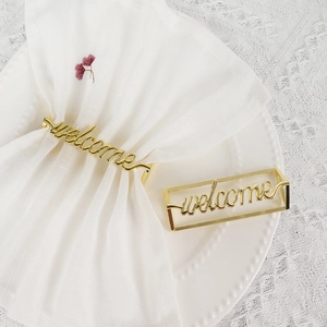 Elegante portatovagliolo in metallo dorato con scritta Welcome su tessuto bianco
