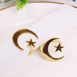Elegant gold celestial napkin rings with moon and star design on white cloth napkin