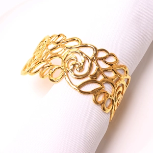 Elegant gold hollow rose metal napkin ring set on a white linen for table decor