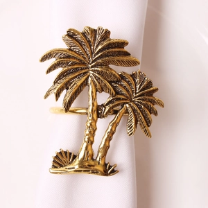 Close-up of vintage gold coconut tree napkin ring with detailed palm leaf textures