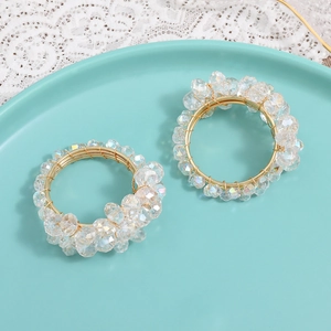 Set of two gold woven napkin rings with crystal beads on a mint tray with lace fabric