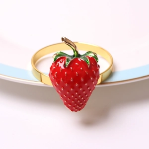Dettaglio portatovagliolo a fragola con smalto rosso e placcatura d'oro su un piatto
