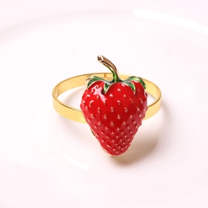 Dettaglio portatovagliolo a forma di fragola rossa smaltata con finitura dorata