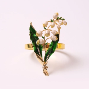 Détail macro du rond de serviette muguet avec feuilles vertes et bourgeons en émail