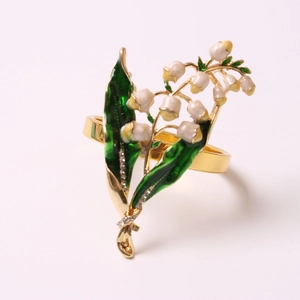 Détail de l'anneau de serviette gardénia blanc avec finition dorée et strass étincelants