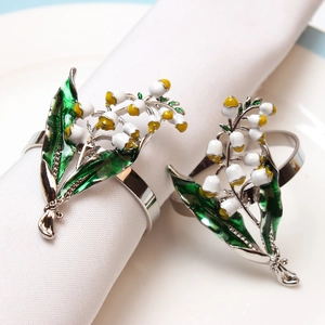 Ronds de serviette muguet élégants en métal argenté avec détails floraux en émail
