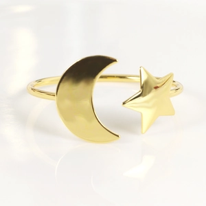 Golden celestial open napkin ring featuring polished metal star and moon motifs