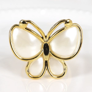 Detailed view of butterfly napkin ring with golden plating and pearlized acrylic inlay