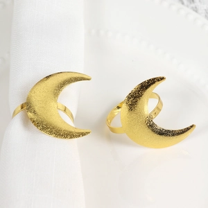 Detailed view of gold crescent moon napkin rings with frosted finish for dinner tables