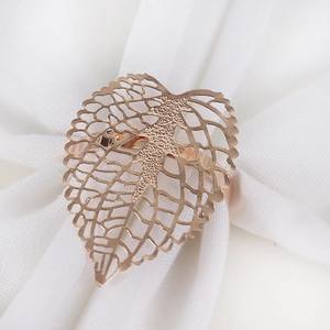 Hollow leaf napkin ring in rose gold finish on a white fabric napkin for table decor