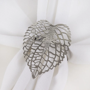 Elegant silver hollow leaf napkin ring with detailed metallic texture on white fabric