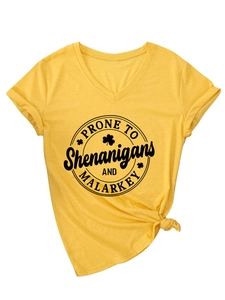 Détail du t-shirt jaune à col en V avec imprimé trèfle et manches courtes à revers stylés