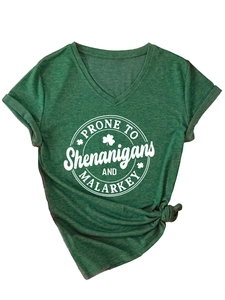 Détail du t-shirt vert foncé à col en V avec motif trèfle et nœud décoratif frontal