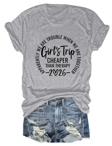 Flat lay of a grey Girl's Trip 2026 t-shirt tucked into distressed blue denim shorts