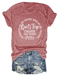 Flat lay of a red Girls Trip t-shirt with distressed denim shorts on white background